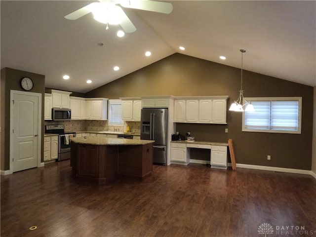 kitchen featuring dark hardwood / wood-style flooring, backsplash, decorative light fixtures, white cabinets, and appliances with stainless steel finishes