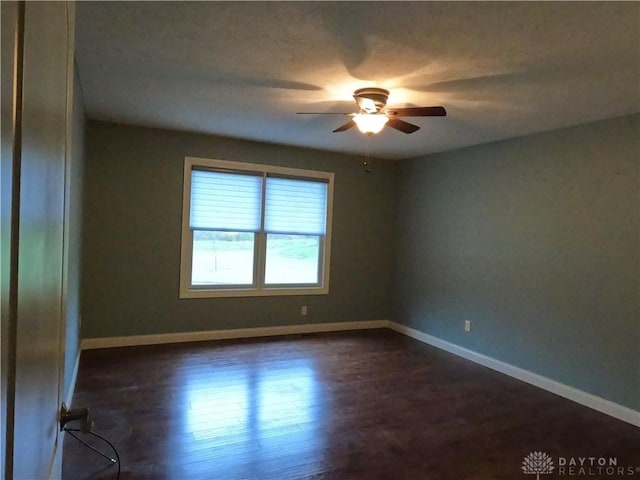 empty room with ceiling fan and dark wood-type flooring