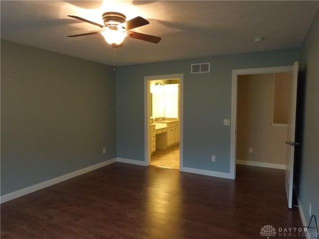 unfurnished bedroom featuring connected bathroom, ceiling fan, and dark hardwood / wood-style floors