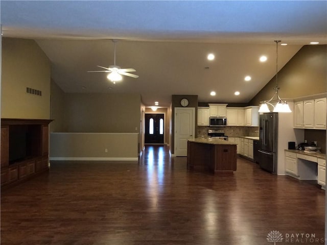 kitchen with white cabinetry, a center island, tasteful backsplash, pendant lighting, and appliances with stainless steel finishes