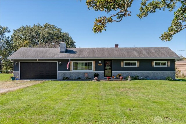 ranch-style home featuring a garage and a front lawn