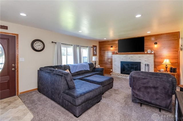 living area with wooden walls, recessed lighting, a fireplace, and baseboards