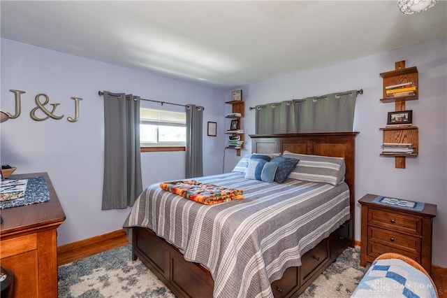 bedroom with baseboards and wood finished floors