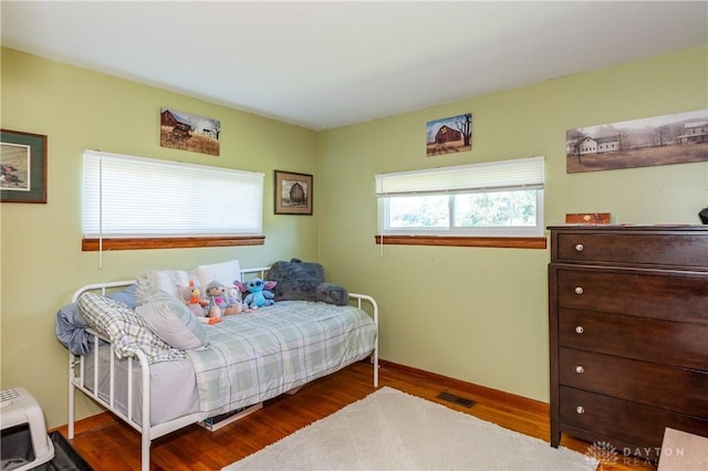 bedroom featuring visible vents, wood finished floors, and baseboards