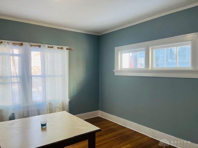 office space featuring plenty of natural light, dark hardwood / wood-style flooring, and ornamental molding