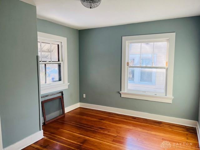 spare room featuring plenty of natural light and dark hardwood / wood-style flooring