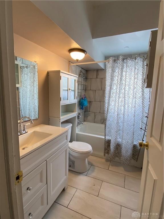 full bathroom featuring toilet, shower / bath combo with shower curtain, vanity, and tile patterned flooring