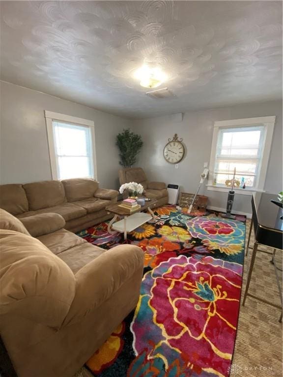 living room with a textured ceiling and carpet floors