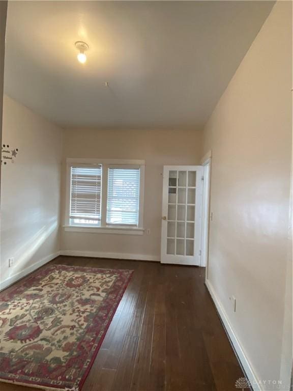 unfurnished room with dark hardwood / wood-style flooring