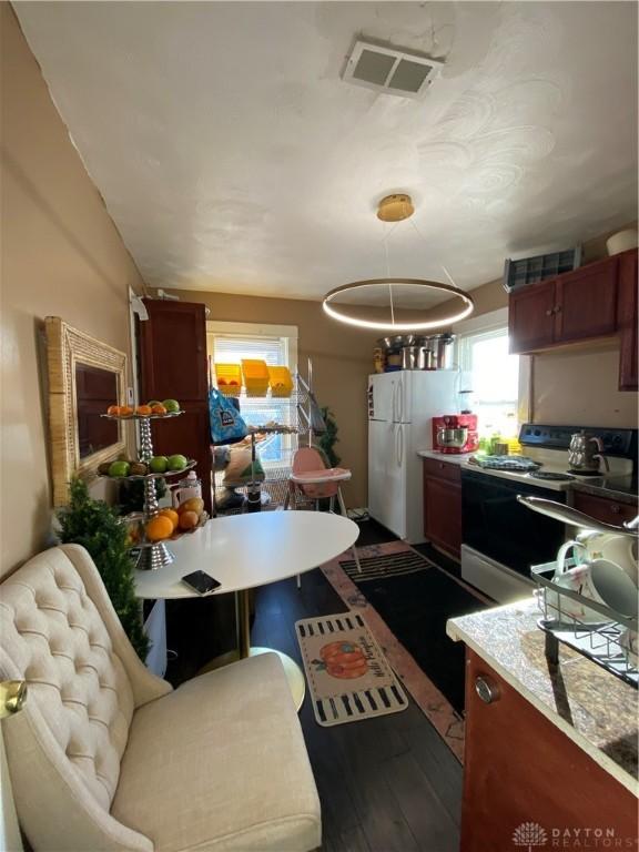 kitchen with white appliances and hardwood / wood-style flooring