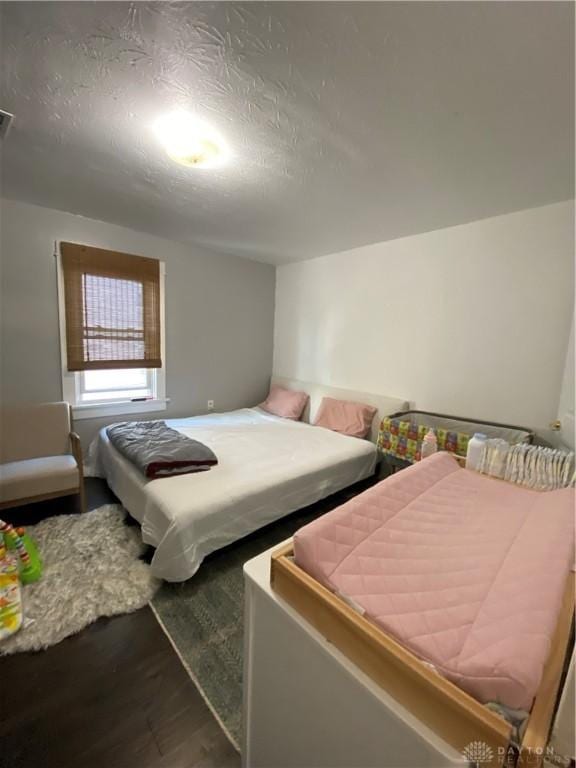 bedroom featuring wood-type flooring and a textured ceiling