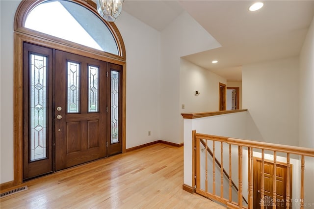 foyer entrance with a chandelier and light wood-type flooring