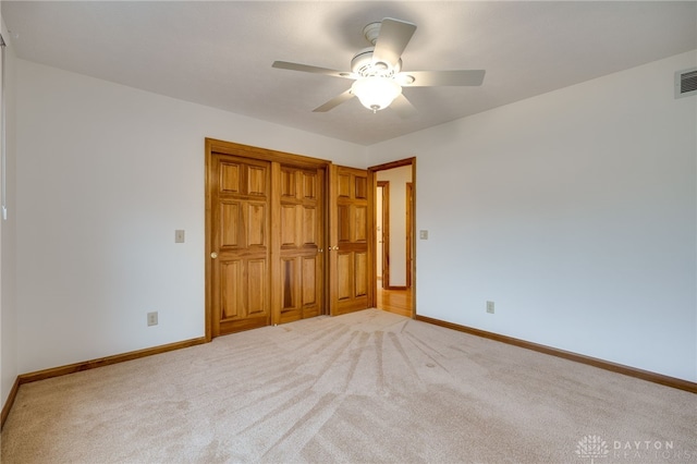 unfurnished bedroom featuring ceiling fan and light colored carpet