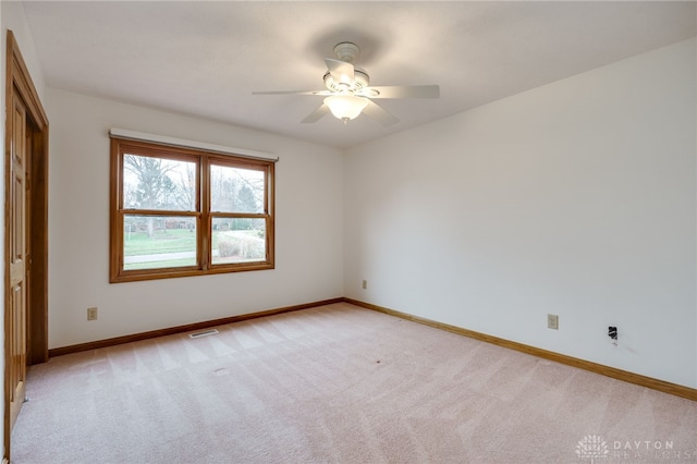 carpeted spare room featuring ceiling fan