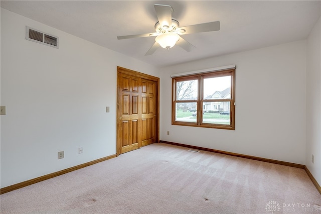 carpeted spare room featuring ceiling fan