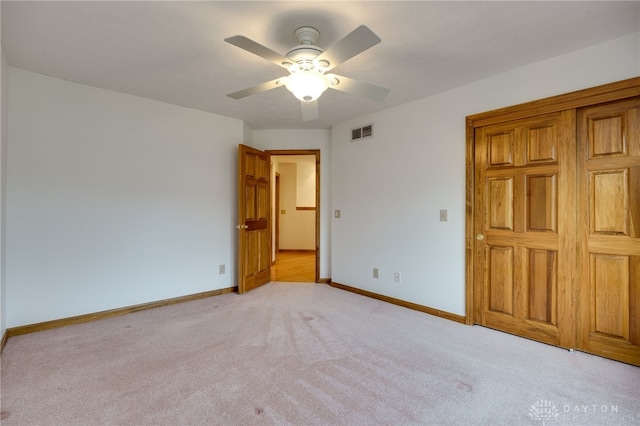 unfurnished bedroom with ceiling fan and light colored carpet