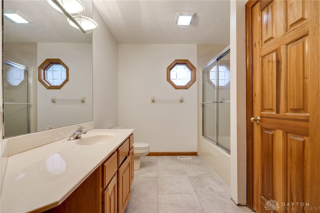 full bathroom featuring toilet, a textured ceiling, shower / bath combination with glass door, tile patterned floors, and vanity