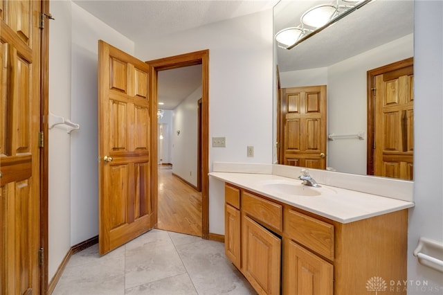 bathroom featuring a textured ceiling, vanity, and tile patterned flooring