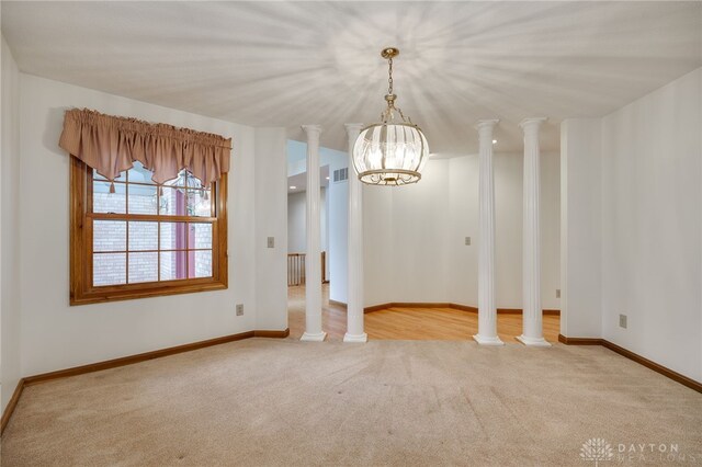 unfurnished dining area with light colored carpet and an inviting chandelier