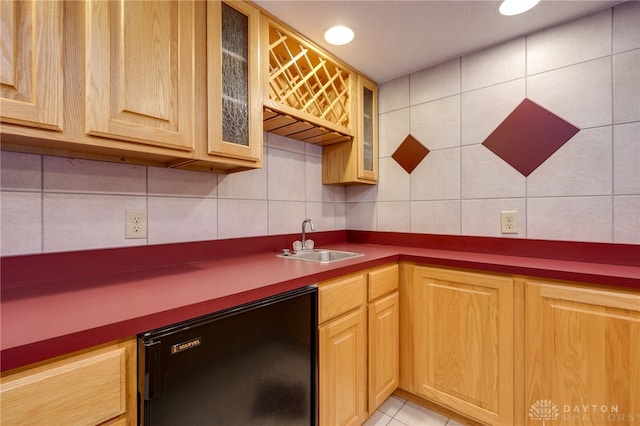 kitchen featuring sink, backsplash, fridge, and light tile patterned flooring