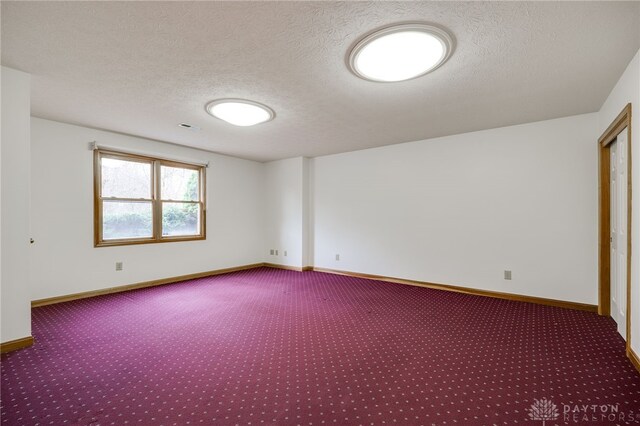 unfurnished room featuring carpet floors and a textured ceiling