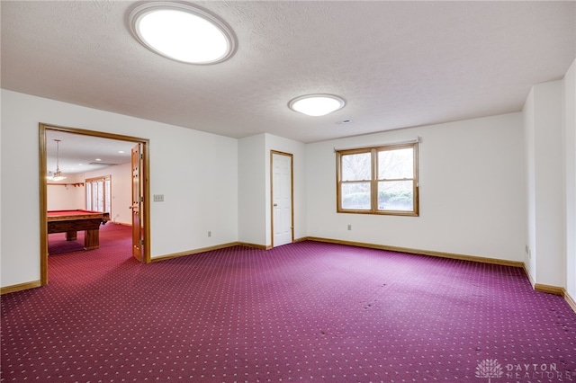 empty room featuring billiards, a textured ceiling, and carpet floors