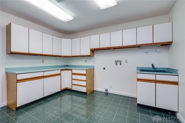 kitchen with sink, white cabinetry, and a textured ceiling