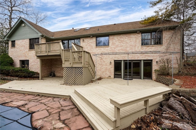 back of property featuring a pool side deck