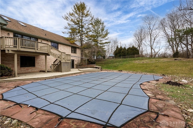 view of swimming pool featuring a patio area, a wooden deck, and a yard