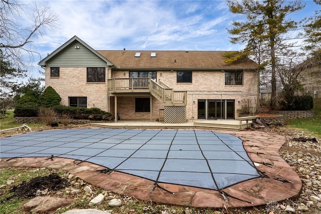 back of property featuring a covered pool and a patio