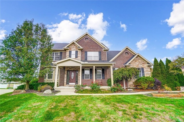 craftsman-style house featuring covered porch and a front lawn