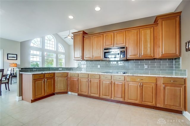 kitchen with ceiling fan, backsplash, kitchen peninsula, vaulted ceiling, and black electric stovetop