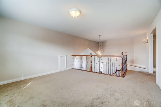 carpeted spare room with a chandelier