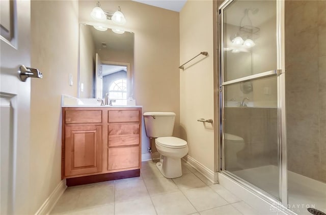 bathroom with vanity, a shower with door, tile patterned flooring, and toilet