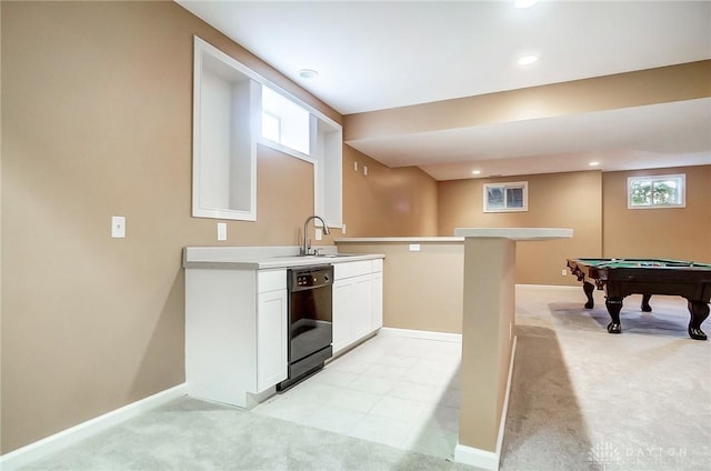 kitchen featuring white cabinetry, dishwasher, sink, light colored carpet, and pool table