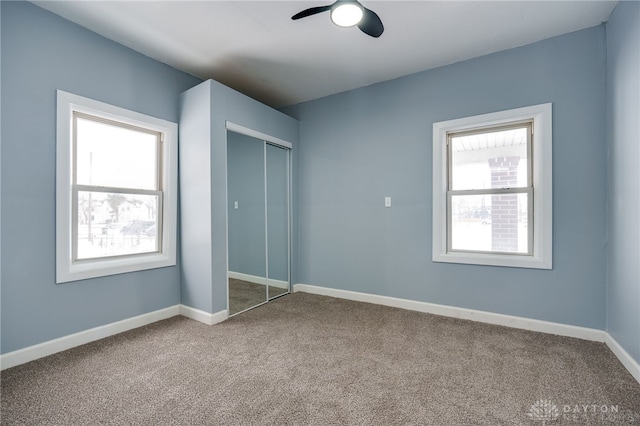 unfurnished bedroom with ceiling fan, carpet floors, and a closet