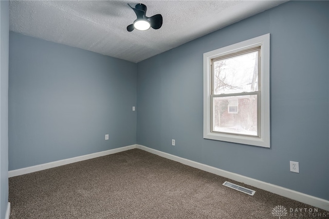 carpeted spare room with ceiling fan and a textured ceiling