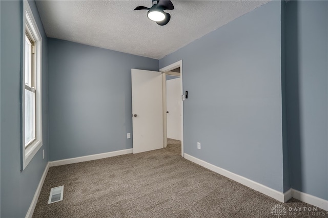 spare room featuring carpet and a textured ceiling