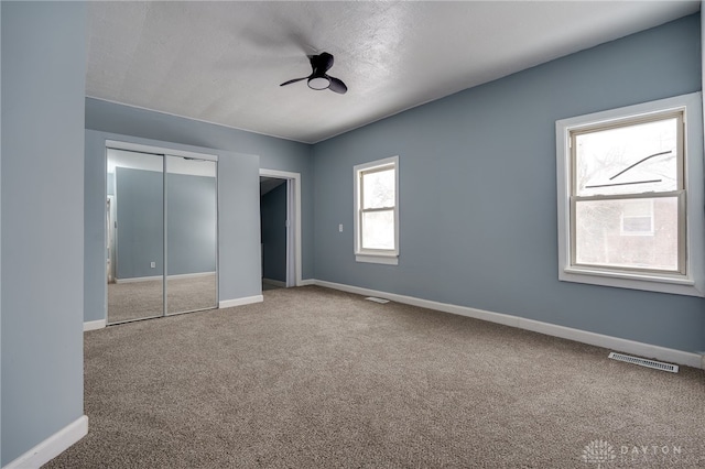 unfurnished bedroom featuring ceiling fan, carpet floors, and a closet