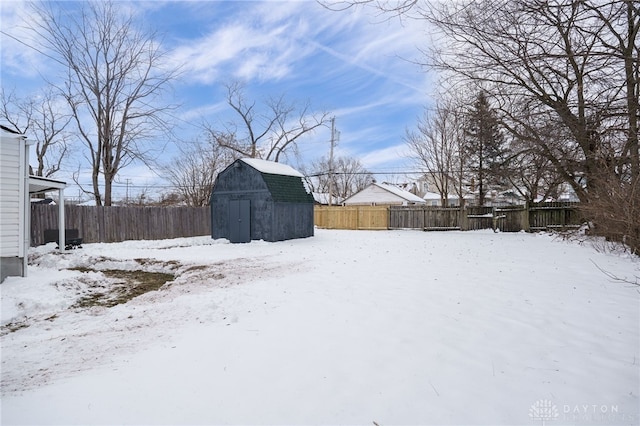 yard layered in snow featuring a storage unit