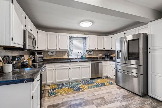 kitchen featuring sink, white cabinets, stainless steel appliances, and hardwood / wood-style flooring