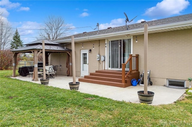 rear view of house featuring a gazebo, a lawn, and a patio