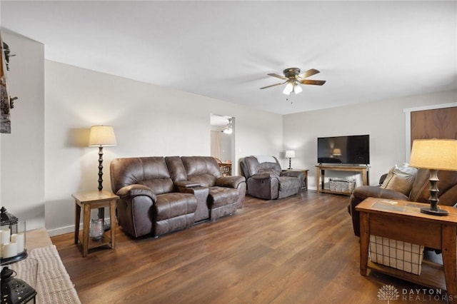 living room featuring dark wood-type flooring and ceiling fan