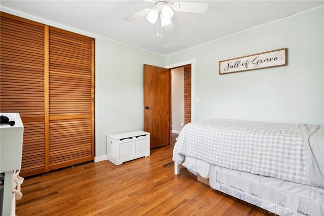 bedroom with ceiling fan, a closet, and wood-type flooring