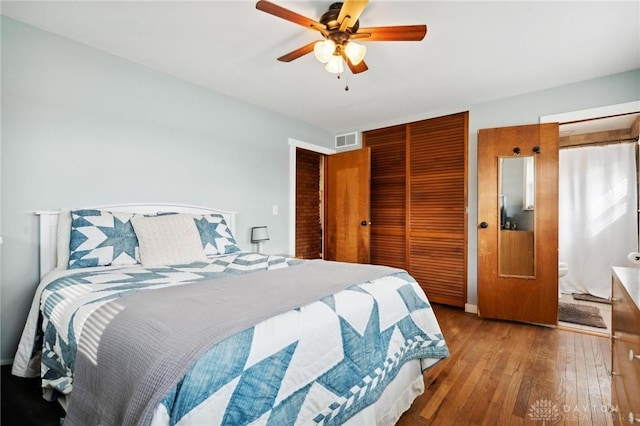 bedroom featuring ceiling fan, wood-type flooring, ensuite bathroom, and a closet