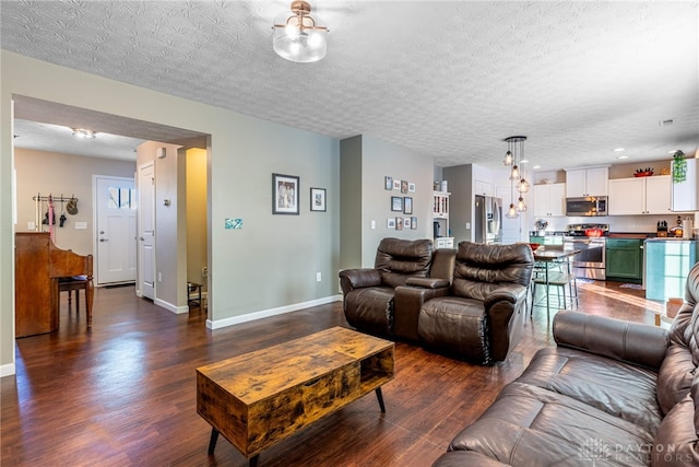 living room featuring a textured ceiling and dark hardwood / wood-style floors