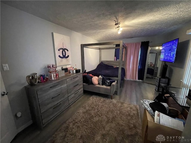 bedroom featuring wood-type flooring and a textured ceiling