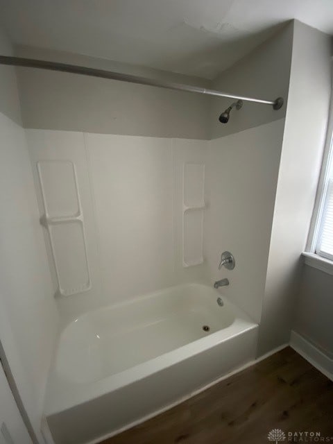 bathroom featuring wood-type flooring and bathtub / shower combination