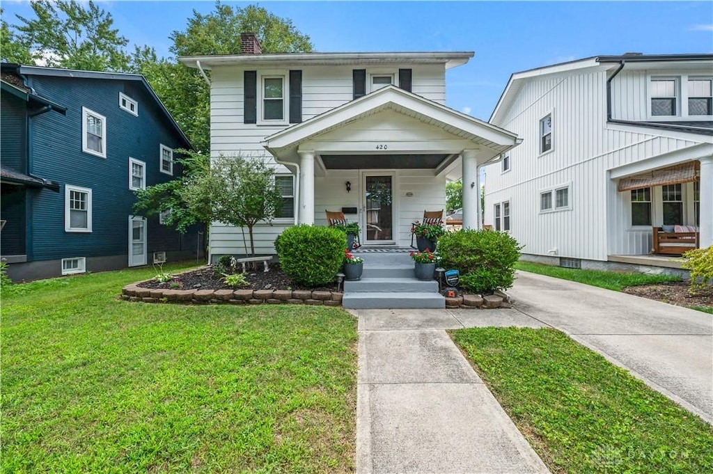 view of front facade featuring covered porch and a front yard