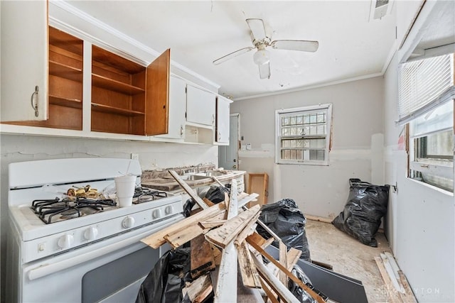 kitchen with white cabinetry, gas range gas stove, ceiling fan, sink, and crown molding